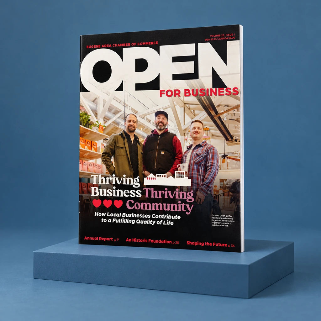 Eugene Area Chamber of Commerce Open for Business magazine standing on a slate-blue studio riser.