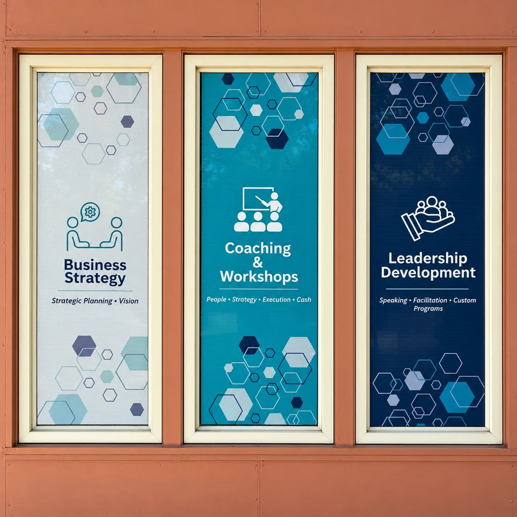 Three installed window graphics promoting business strategy, coaching and workshops, and leadership development.