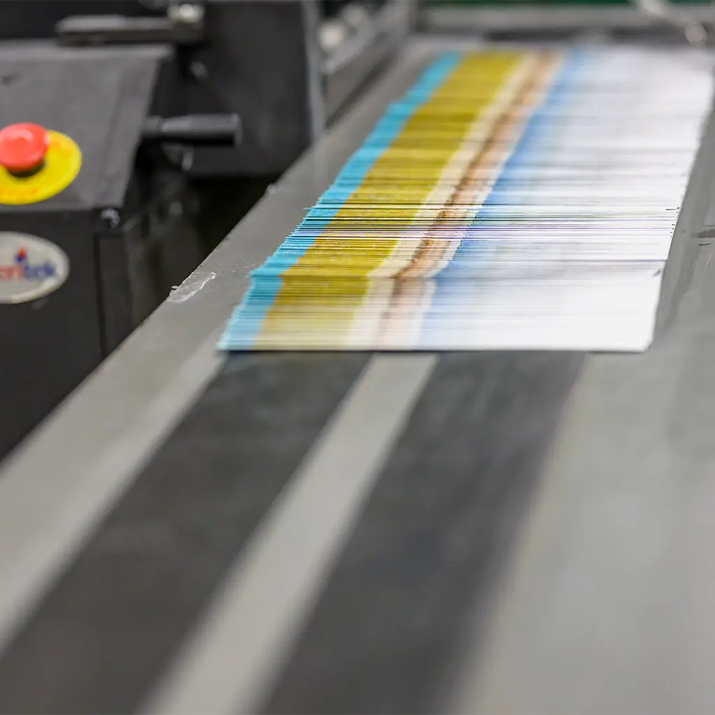 An overlapping row of printed mail pieces on a conveyor belt.