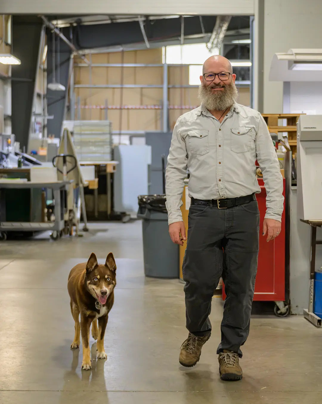 Myron Chadowitz and Thor the dog walking through the Koke Printing shop.